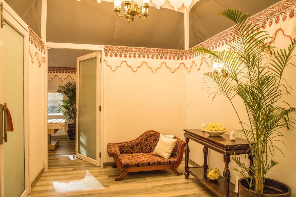 a living room with a chair and a table at The Lalit Laxmi Vilas Palace in Udaipur