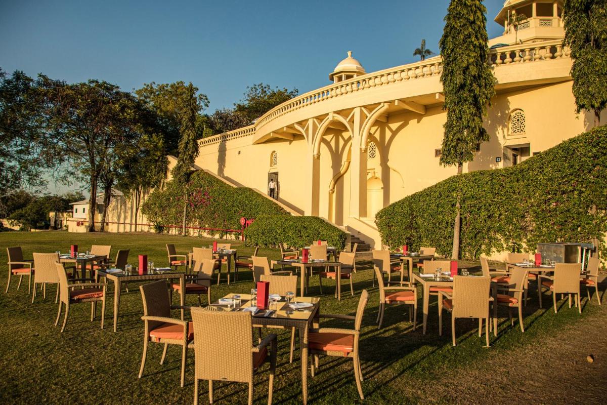 a group of tables and chairs in front of a building at The Lalit Laxmi Vilas Palace in Udaipur