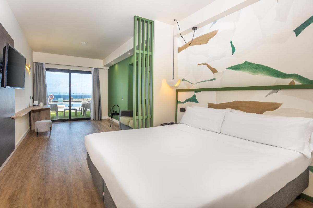 Un dormitorio con una cama grande y una pared con pájaros. en Occidental Roca Negra - Adults Only, en Agaete