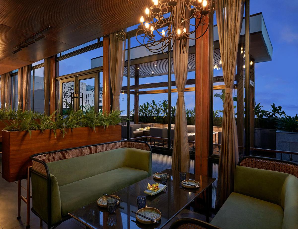 a dining room with a chandelier and a table and chairs at Taj City Centre New Town, Kolkata in Kolkata a dining room with a chandelier and a table and chairs at Taj City Centre New Town, Kolkata in Kolkata