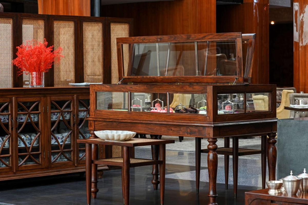 a wooden cabinet with a table and a stool at Grand Hyatt Gurgaon in Gurgaon