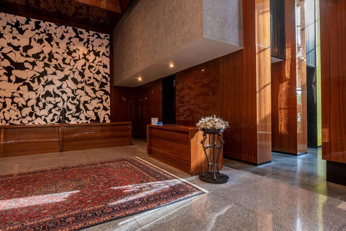 a lobby with a vase of flowers on a rug at Grand Hyatt Gurgaon in Gurgaon