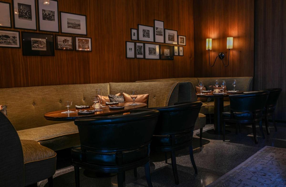 a restaurant with two tables and chairs and pictures on the wall at Grand Hyatt Gurgaon in Gurgaon