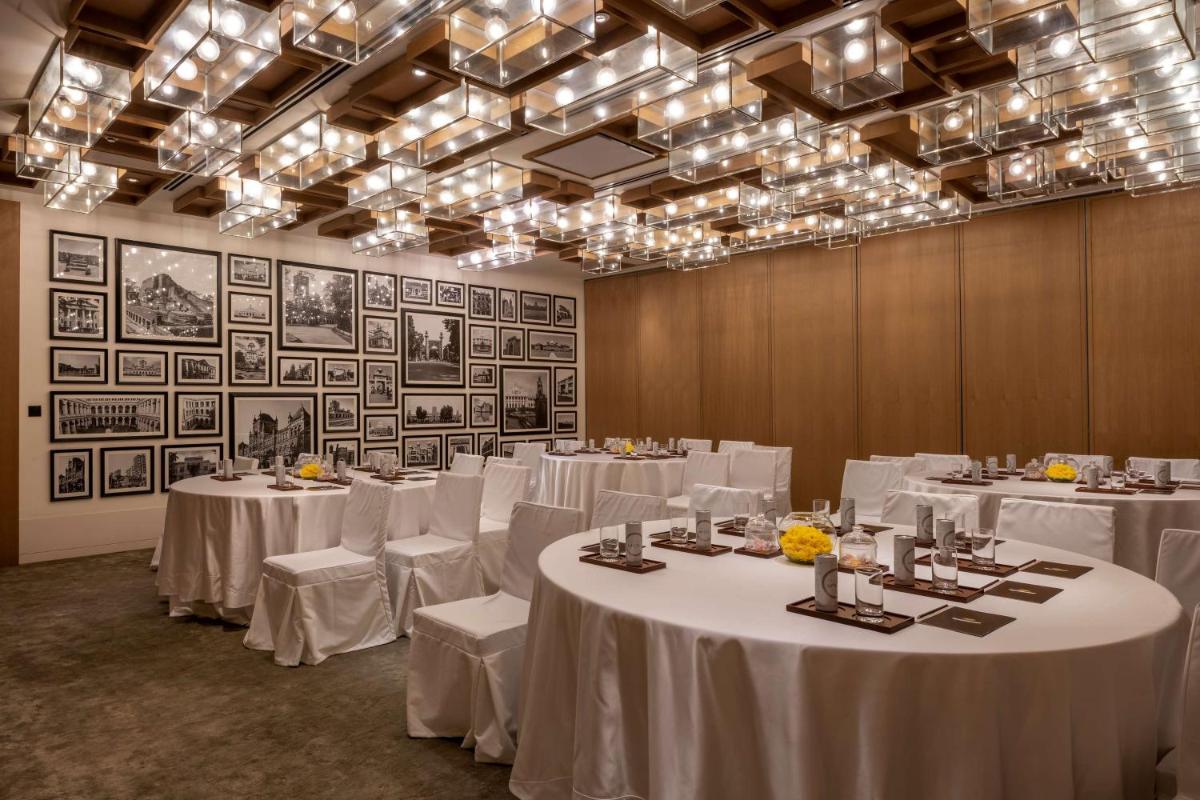 a banquet room with white tables and chairs and chandeliers at Grand Hyatt Gurgaon in Gurgaon