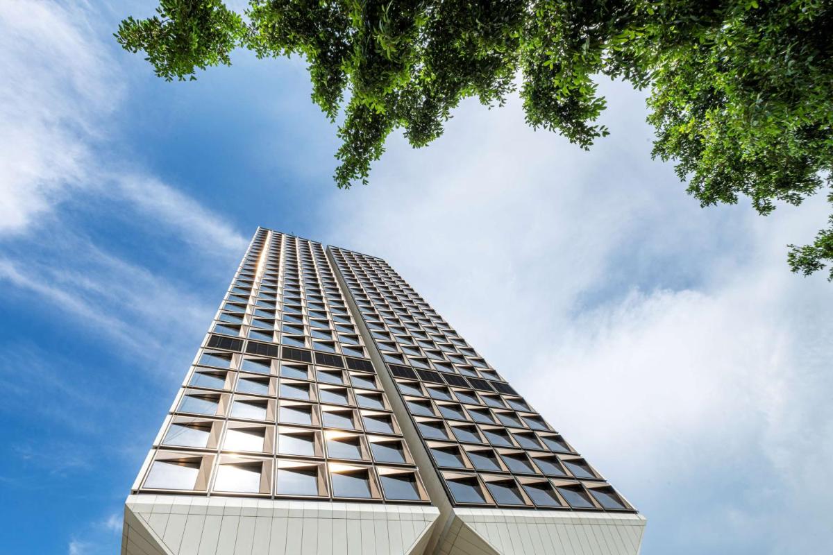 a tall building with a blue sky in the background at Grand Hyatt Gurgaon in Gurgaon