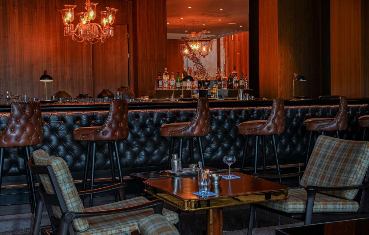 a bar with a row of stools in a restaurant at Grand Hyatt Gurgaon in Gurgaon