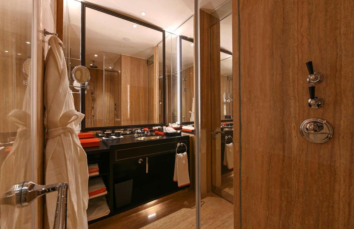 a bathroom with a sink and a shower with a mirror at Grand Hyatt Gurgaon in Gurgaon