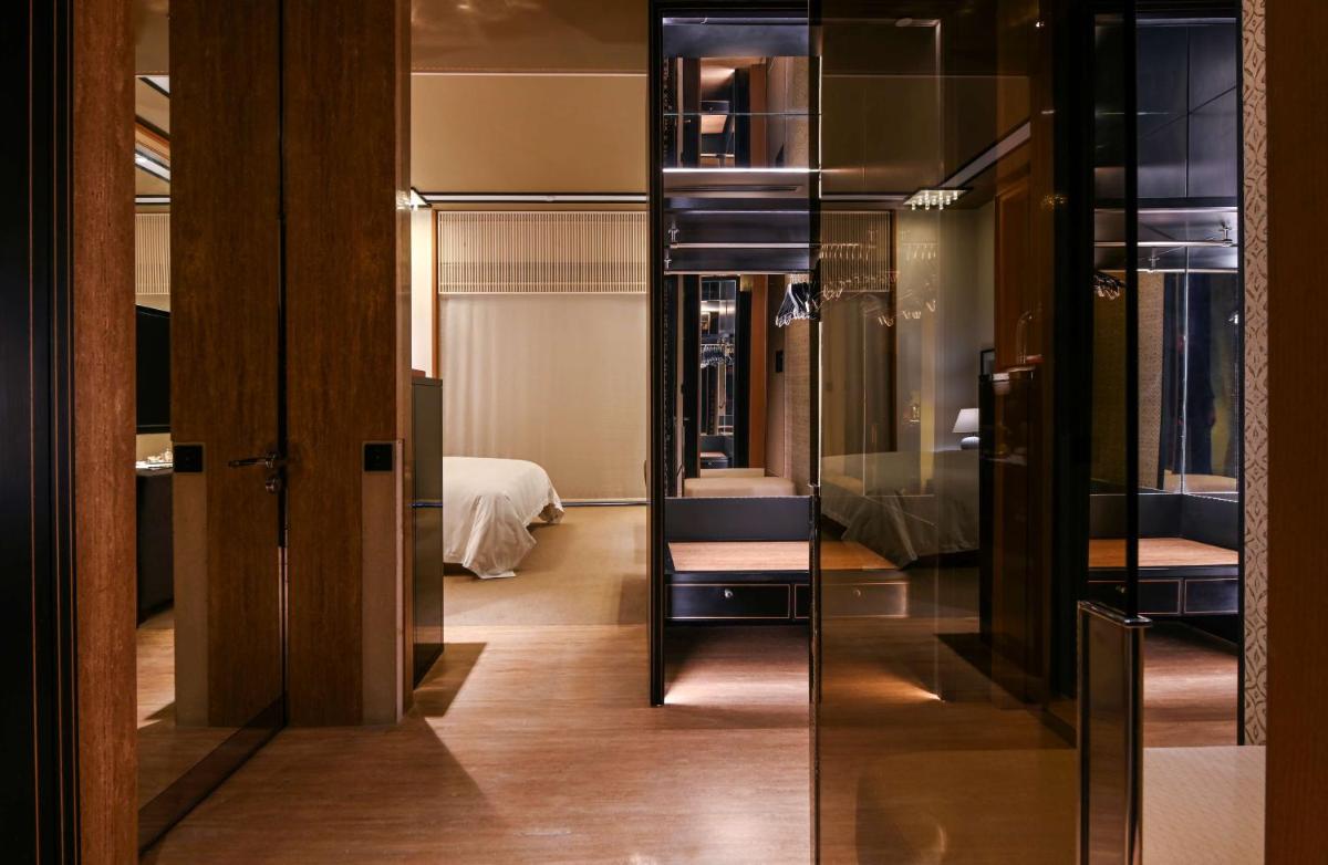 a room with a mirror and a chair and a bed at Grand Hyatt Gurgaon in Gurgaon