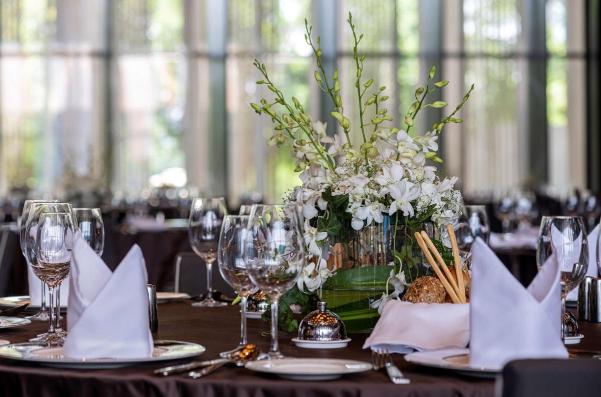a table with a vase of white flowers on it at Grand Hyatt Gurgaon in Gurgaon