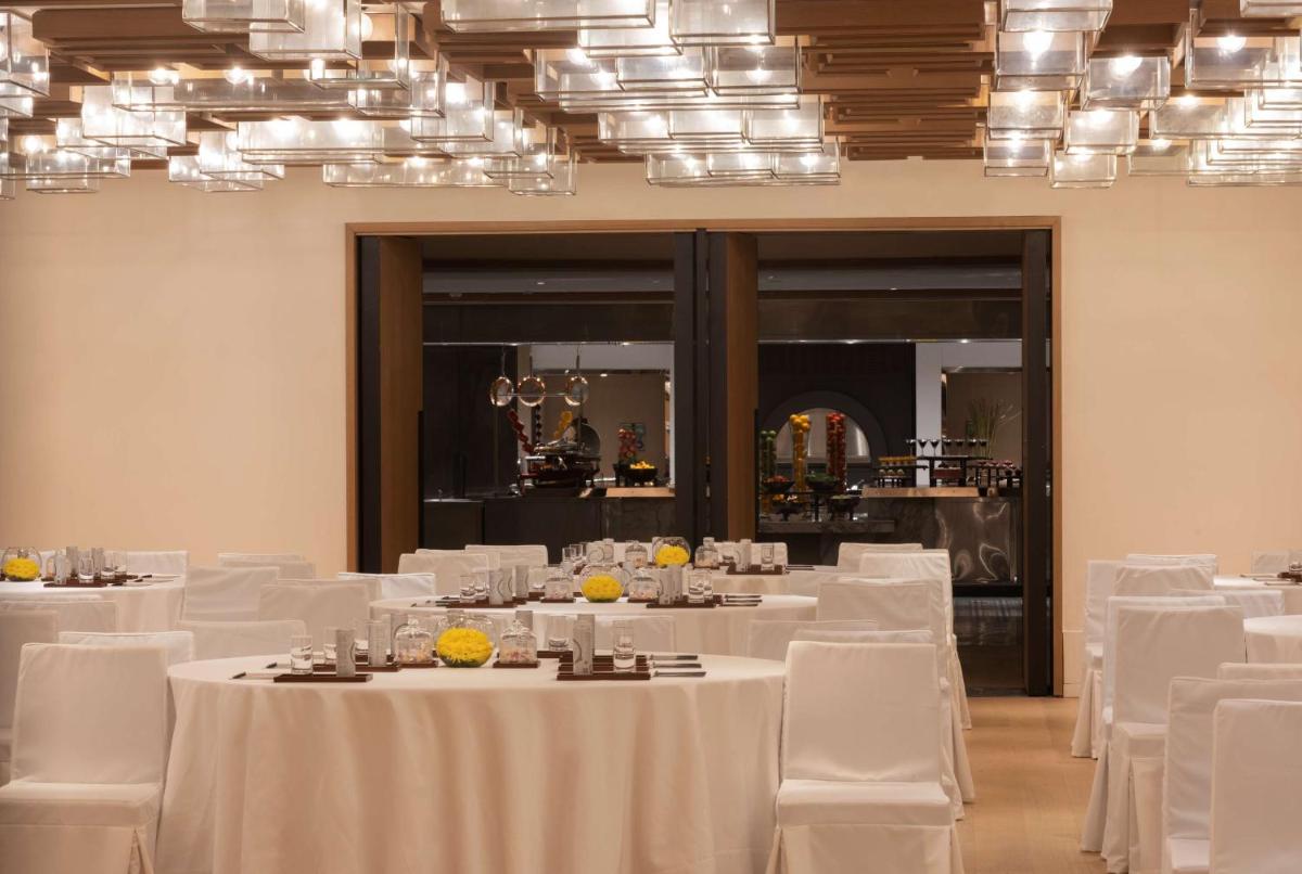 a dining room with white tables and white chairs at Grand Hyatt Gurgaon in Gurgaon