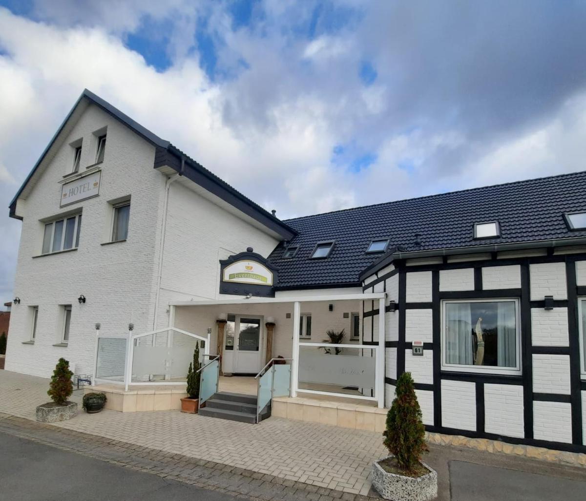 ein weißes und schwarzes Haus mit Auffahrt in der Unterkunft Eventhaus Schamin in Erpen