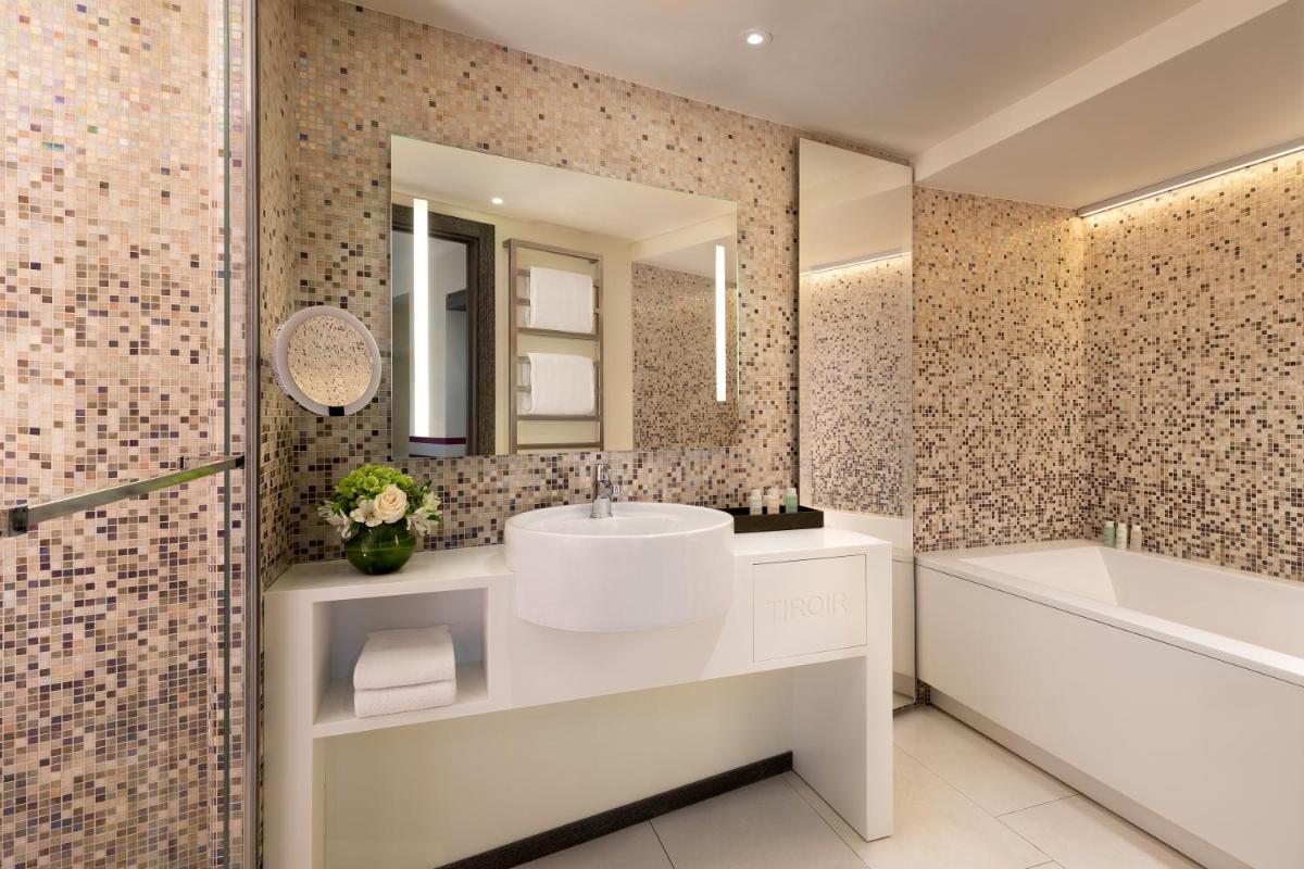 une salle de bains avec lavabo, baignoire et miroir dans l'établissement Hôtel de Paris Saint-Tropez, à Saint-Tropez 36 autres photos