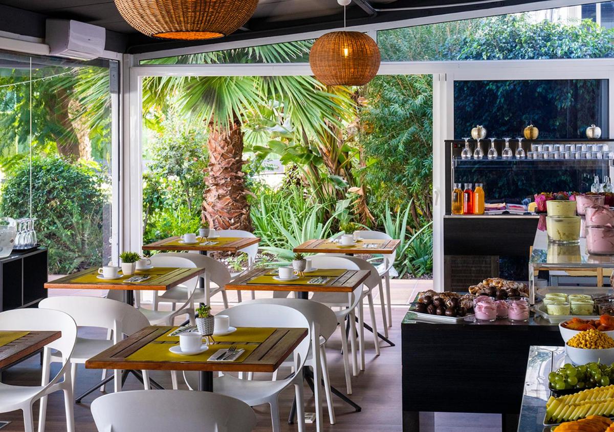 Un restaurante con mesas y sillas y una ventana. en Axel Beach Maspalomas - Adults Only, en Playa del Inglés