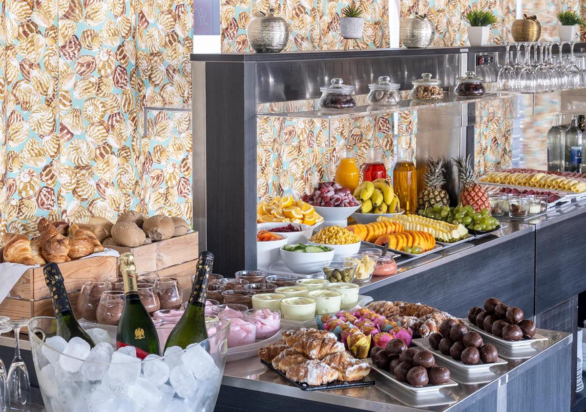 un buffet con mucha comida y botellas de vino en Axel Beach Maspalomas - Adults Only, en Playa del Inglés