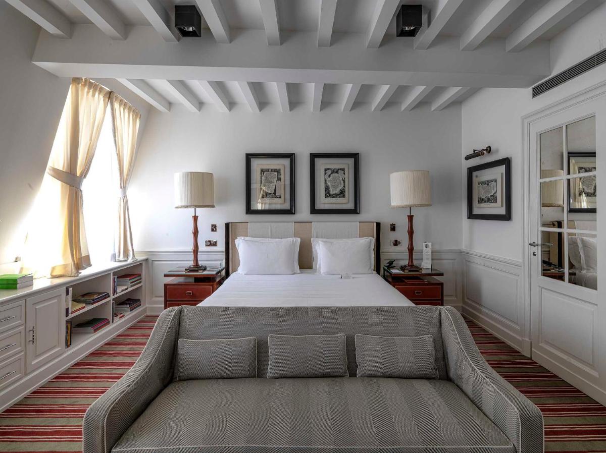 une chambre avec un lit et un canapé dans l'établissement MARQUIS Faubourg Saint-Honoré, à Paris