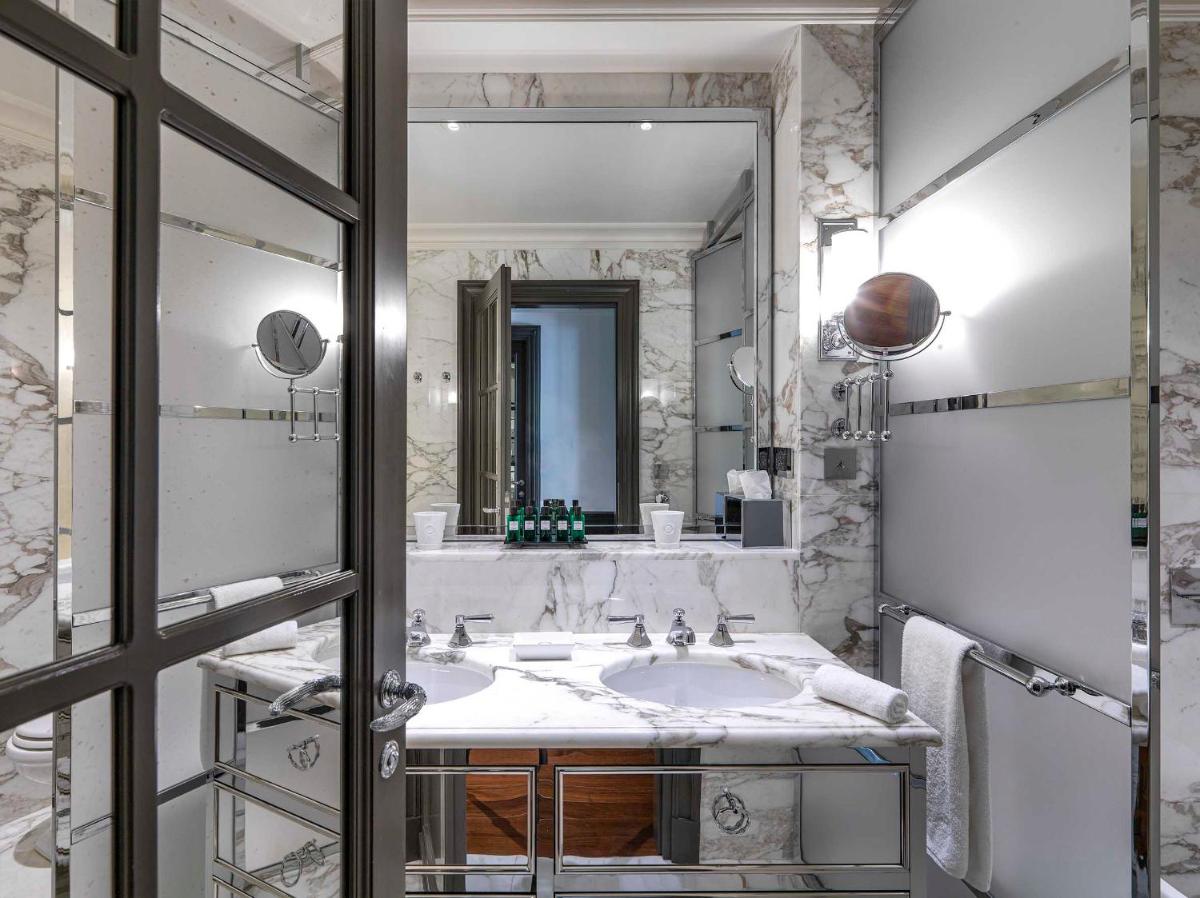 une salle de bain avec un lavabo et un miroir dans l'établissement MARQUIS Faubourg Saint-Honoré, à Paris