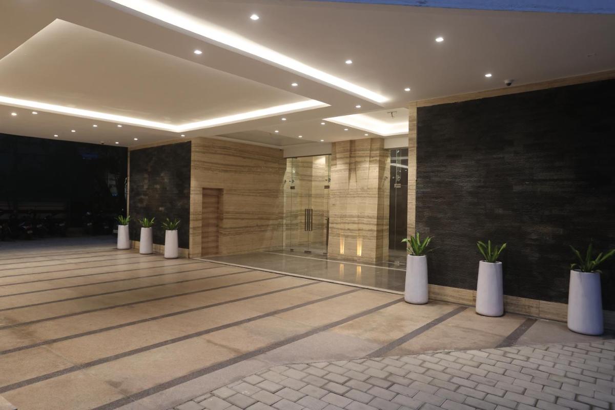 a lobby with potted plants in a building at Pharos Hotels in Chennai