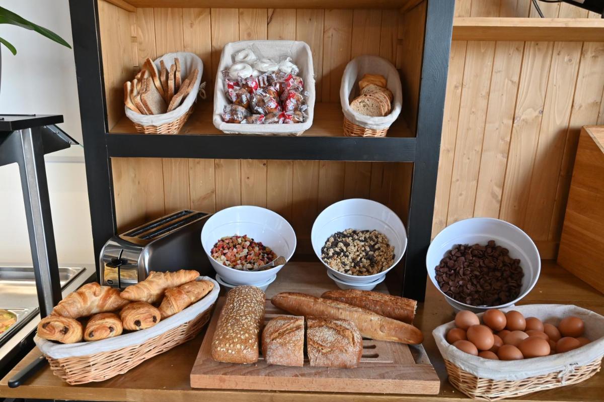 une table avec différents types de pain et autres denrées alimentaires dans l'établissement Le Catalan, à Banyuls-sur-Mer