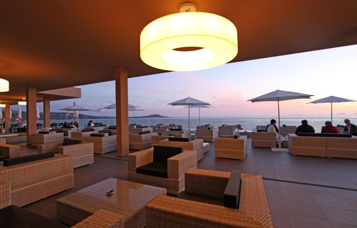 - un restaurant avec des chaises et des parasols offrant une vue sur l'océan dans l'établissement Radisson Blu Resort & Spa, Ajaccio Bay, à Porticcio