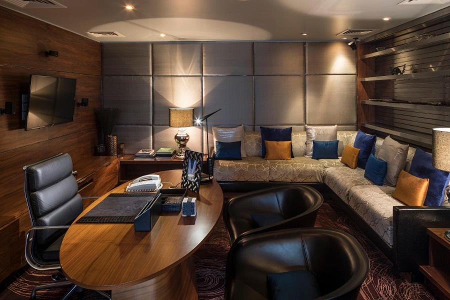 a living room with a couch and a table and chairs at The Park Hyderabad, Banjara Hills near Hussain Sagar Lake in Hyderabad a living room with a couch and a table and chairs at The Park Hyderabad, Banjara Hills near Hussain Sagar Lake in Hyderabad