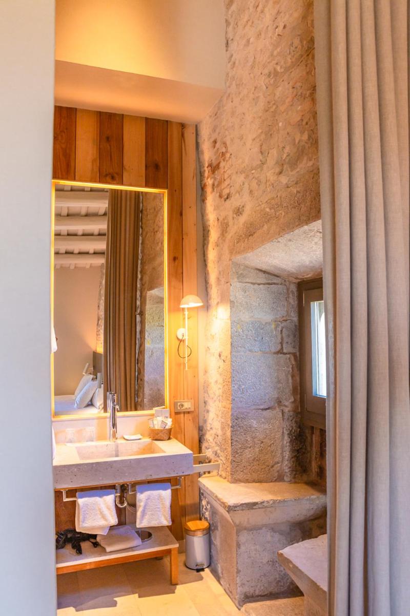 un baño con lavabo y espejo en Hotel Mas Bosch 1526, en Avinyonet de Puigventós un baño con lavabo y espejo en Hotel Mas Bosch 1526, en Avinyonet de Puigventós