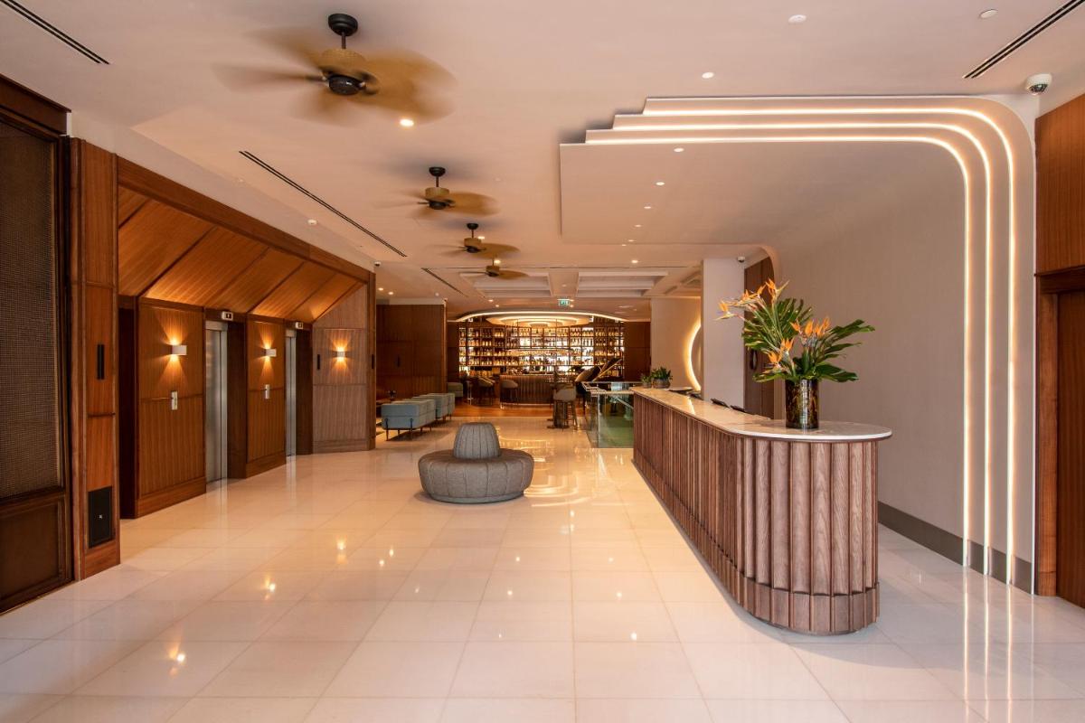 um lobby de hotel com balcão de recepção em SANA Malhoa Hotel em Lisboa