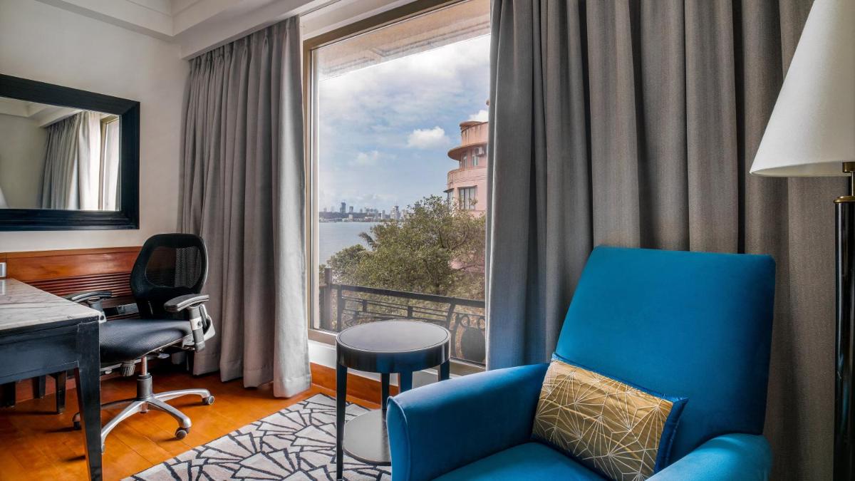 a room with a blue chair and a desk and a window at InterContinental Marine Drive Mumbai by IHG in Mumbai