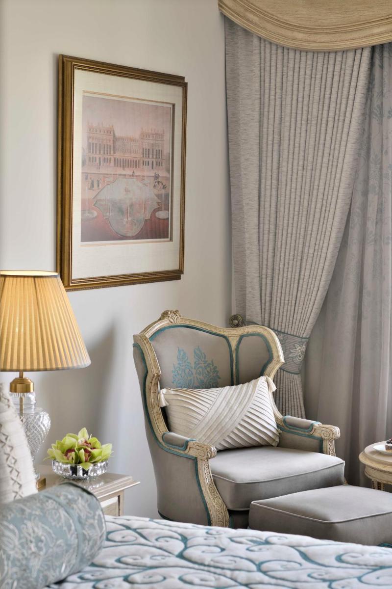 a living room with a chair and a bed at Taj Mahal, New Delhi in New Delhi