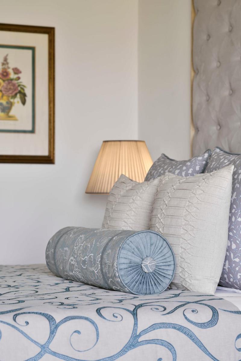 a bedroom with a bed with pillows and a lamp at Taj Mahal, New Delhi in New Delhi