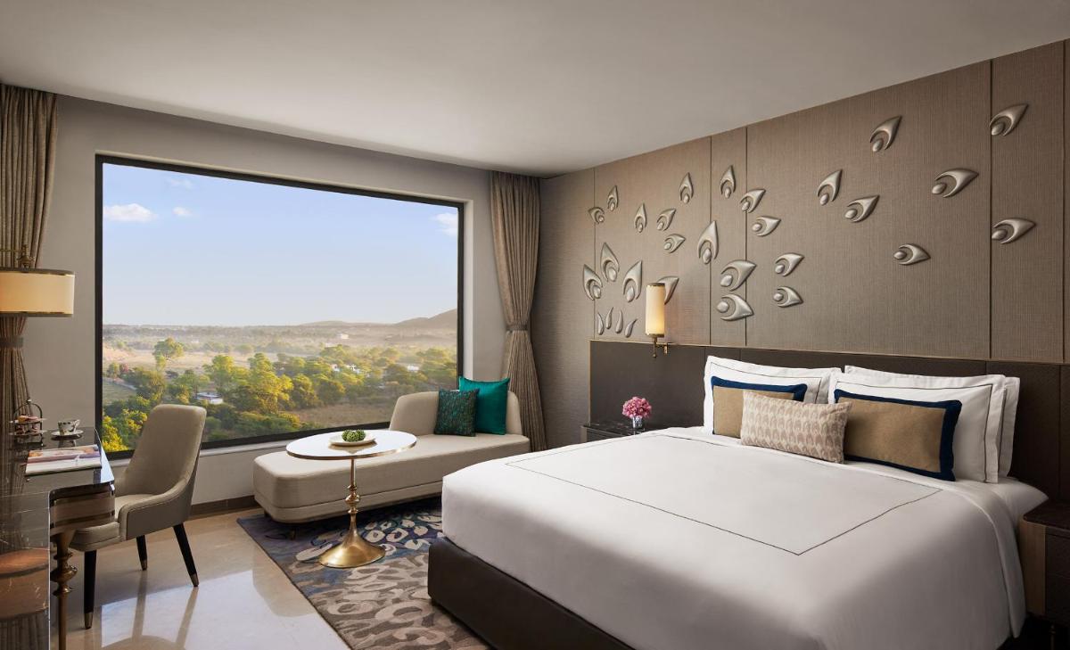a bedroom with a large bed and a large window at Taj Amer, Jaipur in Jaipur