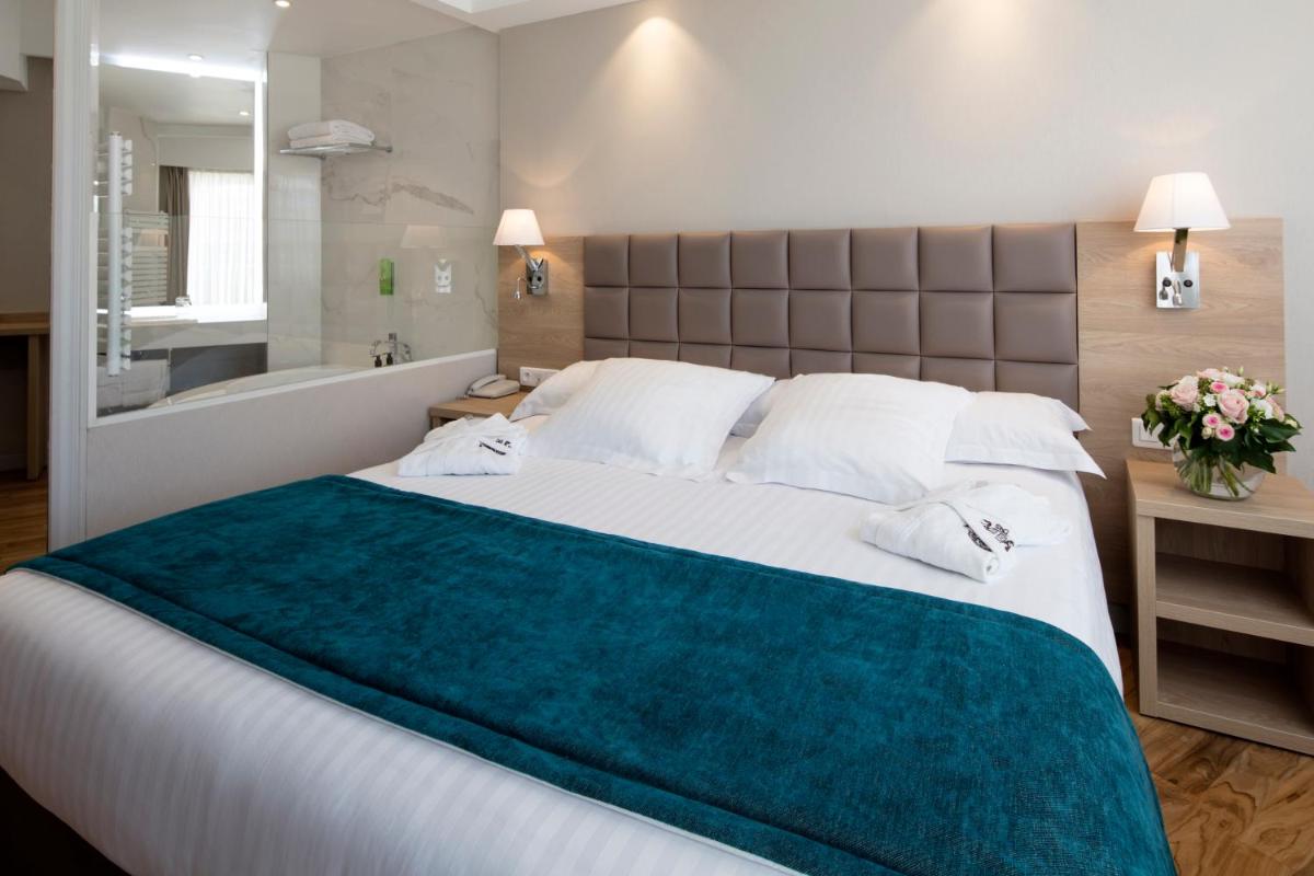 une chambre avec un grand lit et une baignoire dans l'établissement Splendid Hotel & Spa Nice, à Nice