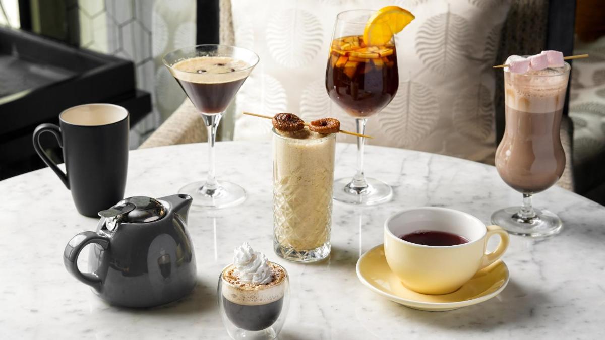 a table topped with glasses of drinks and a cup of coffee at InterContinental Marine Drive Mumbai by IHG in Mumbai