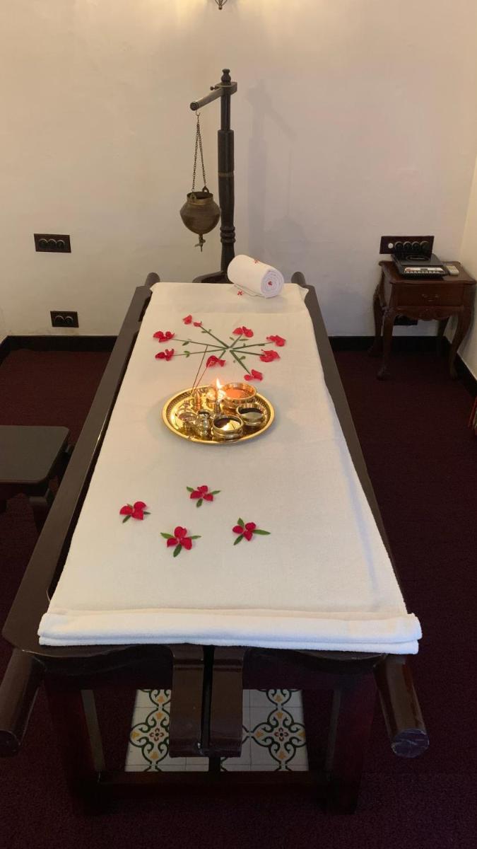 a table with a candle and flowers on it at Forte Kochi in Cochin