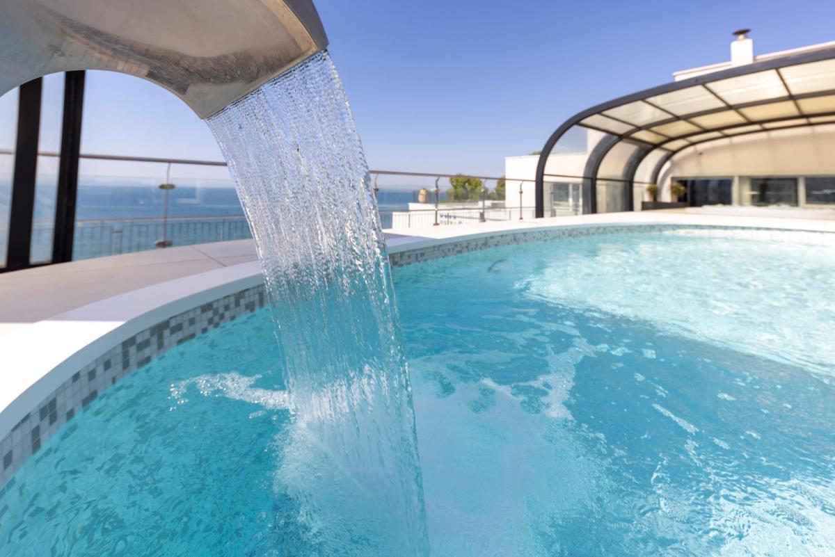 una fuente de agua en una piscina en Hotel & Spa Terraza 4 Sup, en Roses una fuente de agua en una piscina en Hotel & Spa Terraza 4 Sup, en Roses
