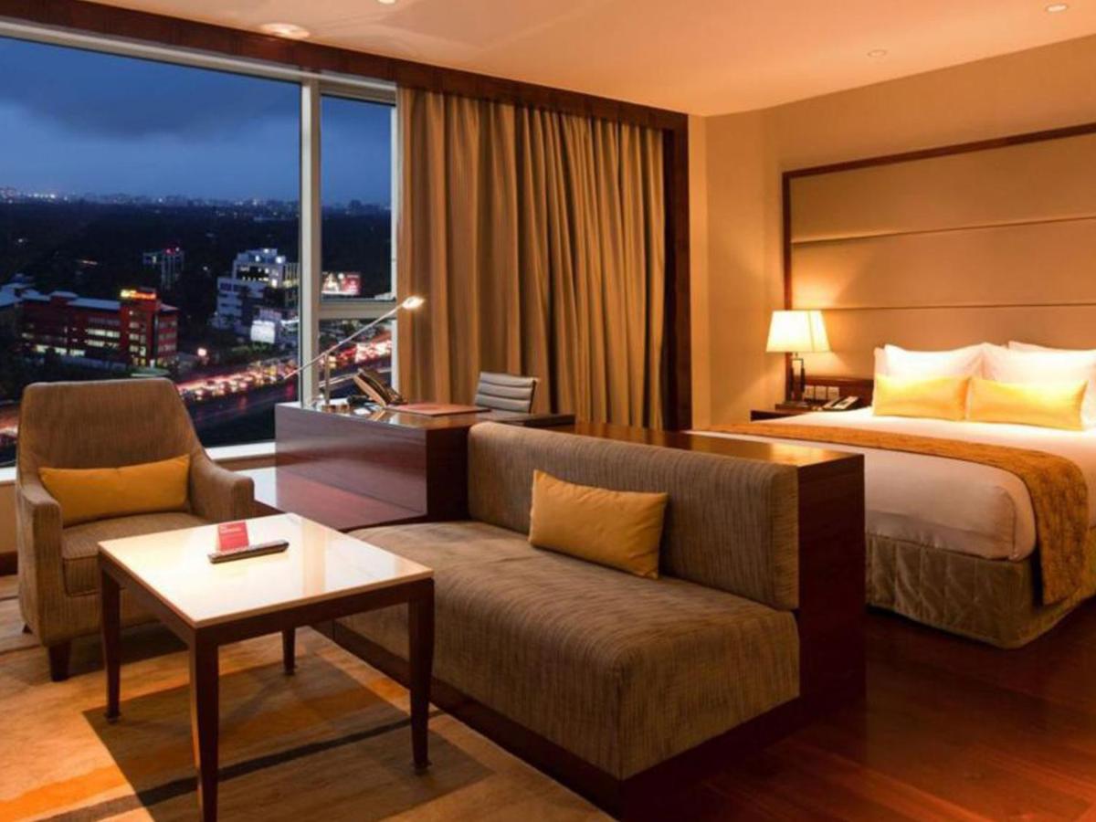 a hotel room with a bed and a couch at Crowne Plaza Kochi by IHG in Cochin