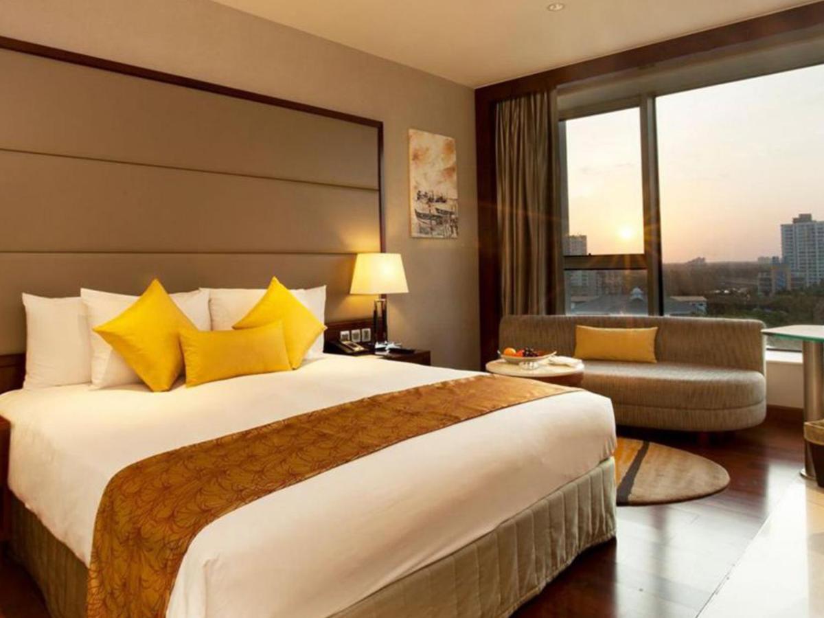 a hotel room with a large bed and a large window at Crowne Plaza Kochi by IHG in Cochin