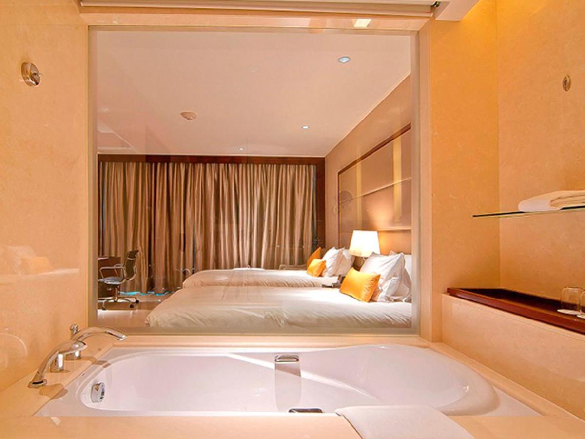 a bathroom with a large bath tub and a bed at Crowne Plaza Kochi by IHG in Cochin