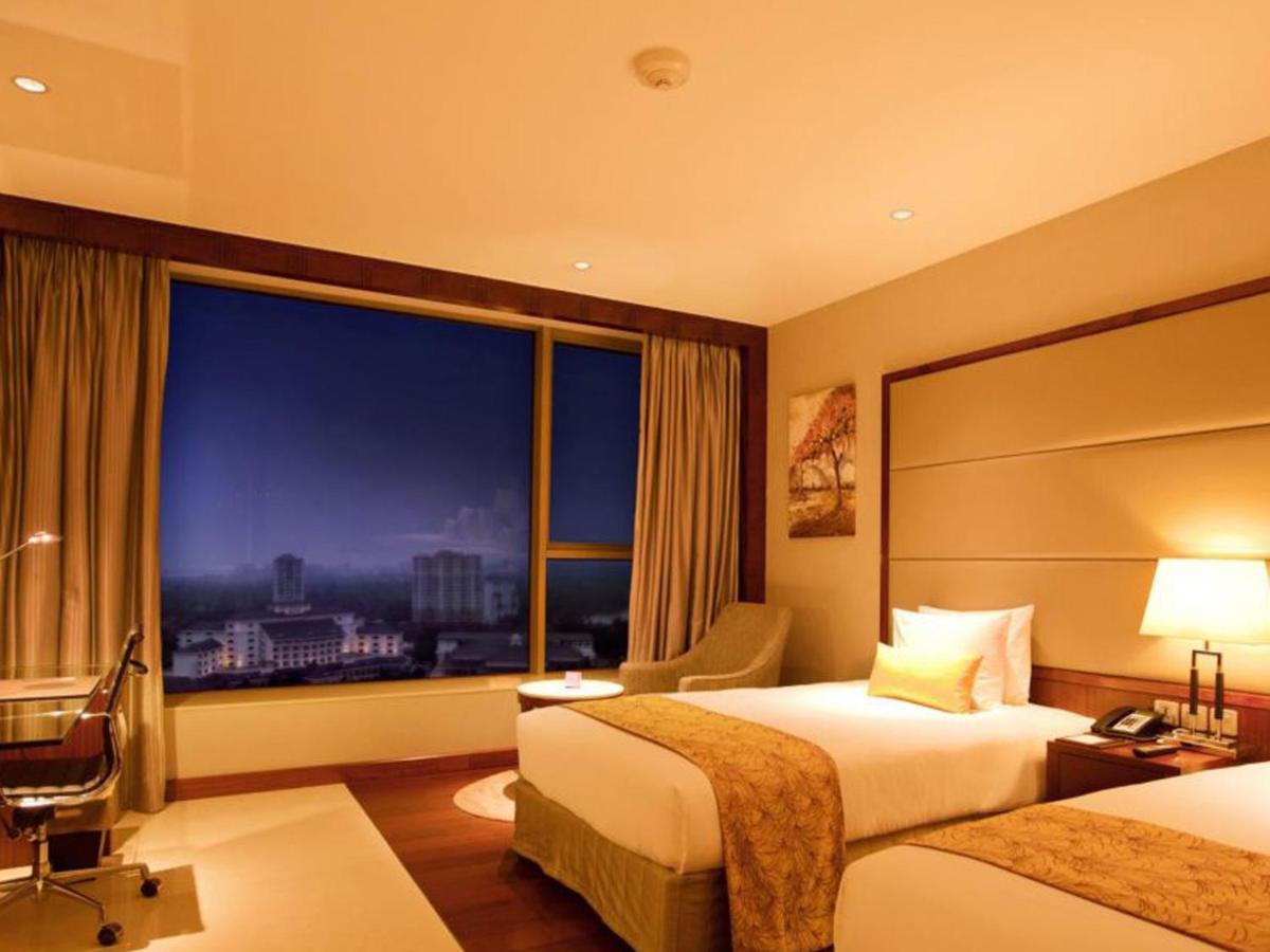 a hotel room with two beds and a large window at Crowne Plaza Kochi by IHG in Cochin