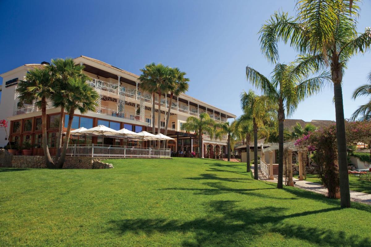 Un gran edificio con palmeras delante. en Lindner Hotel Mallorca Portals Nous, part of JdV by Hyatt, en Portals Nous