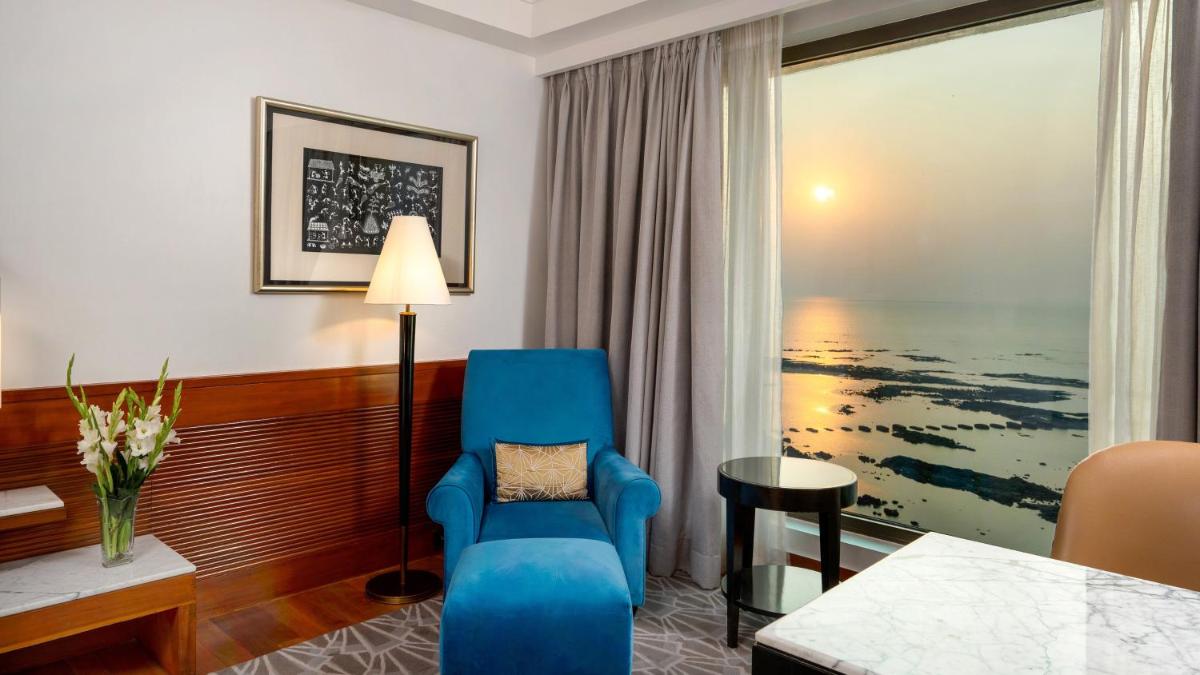 a hotel room with a blue chair and a window at InterContinental Marine Drive Mumbai by IHG in Mumbai