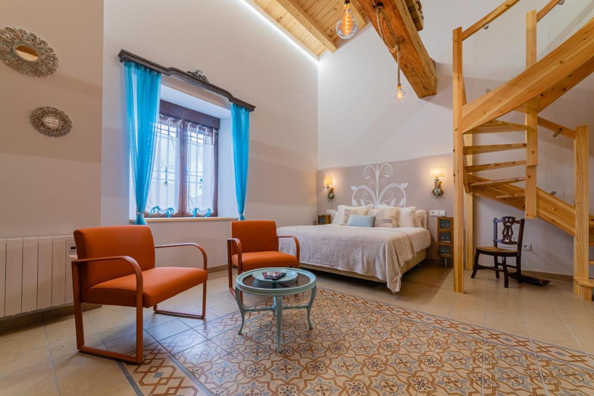 Un dormitorio con una cama y una mesa y sillas. en El Jaraiz de Don Marciano, en Villaverde de Medina