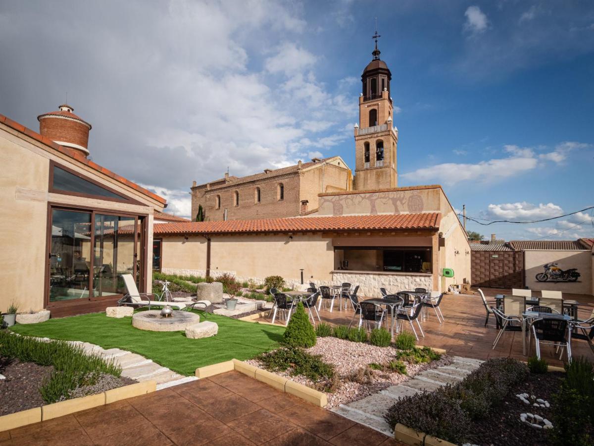 un edificio con una iglesia con una torre de reloj en El Jaraiz de Don Marciano, en Villaverde de Medina