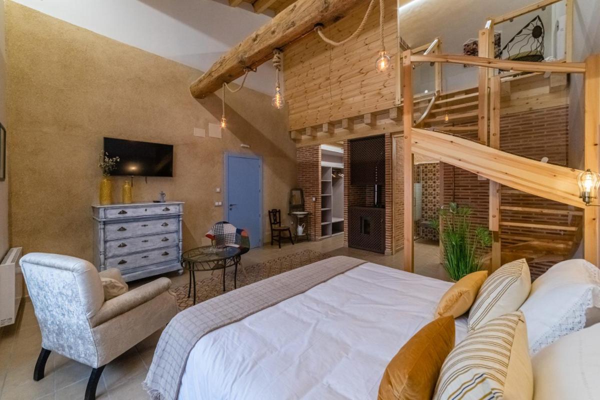 Un dormitorio grande con una cama grande y una silla. en El Jaraiz de Don Marciano, en Villaverde de Medina