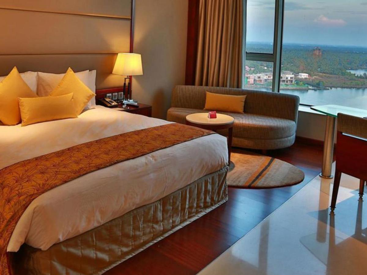 a hotel room with a large bed and a living room at Crowne Plaza Kochi by IHG in Cochin