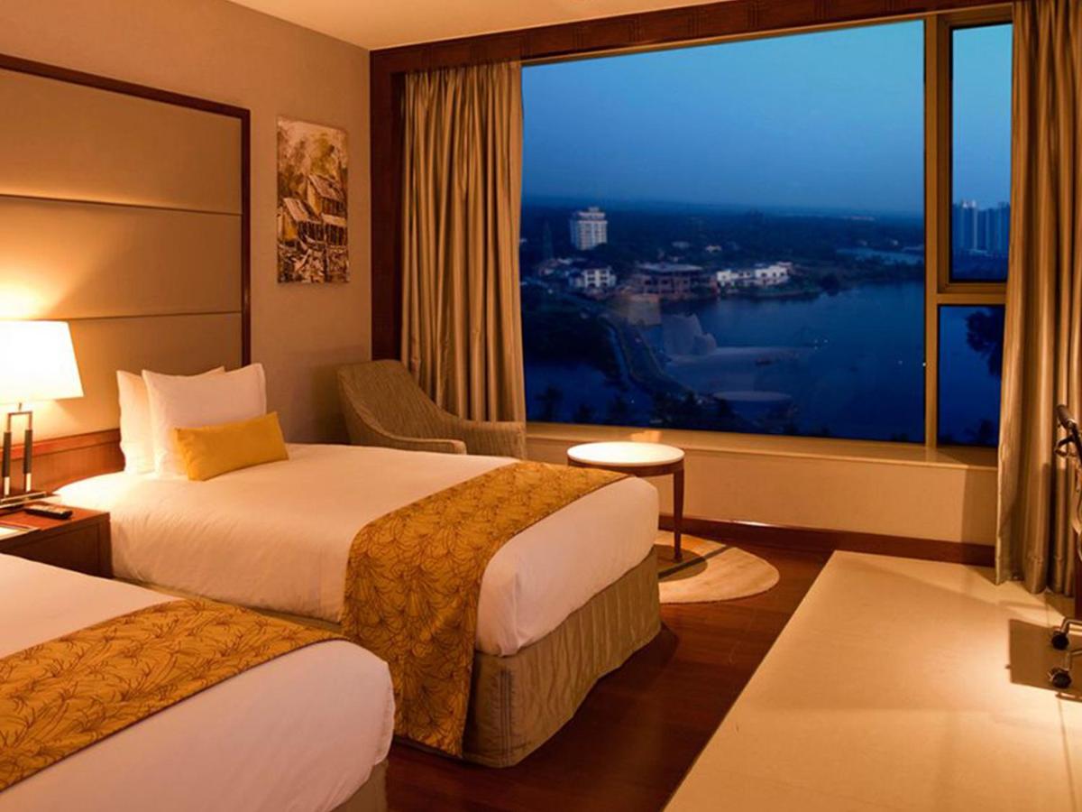 a hotel room with two beds and a large window at Crowne Plaza Kochi by IHG in Cochin