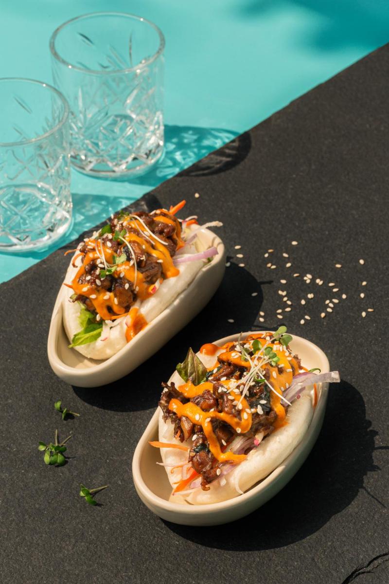 two plates of food on a table with glasses at Hyatt Hyderabad Gachibowli in Hyderabad
