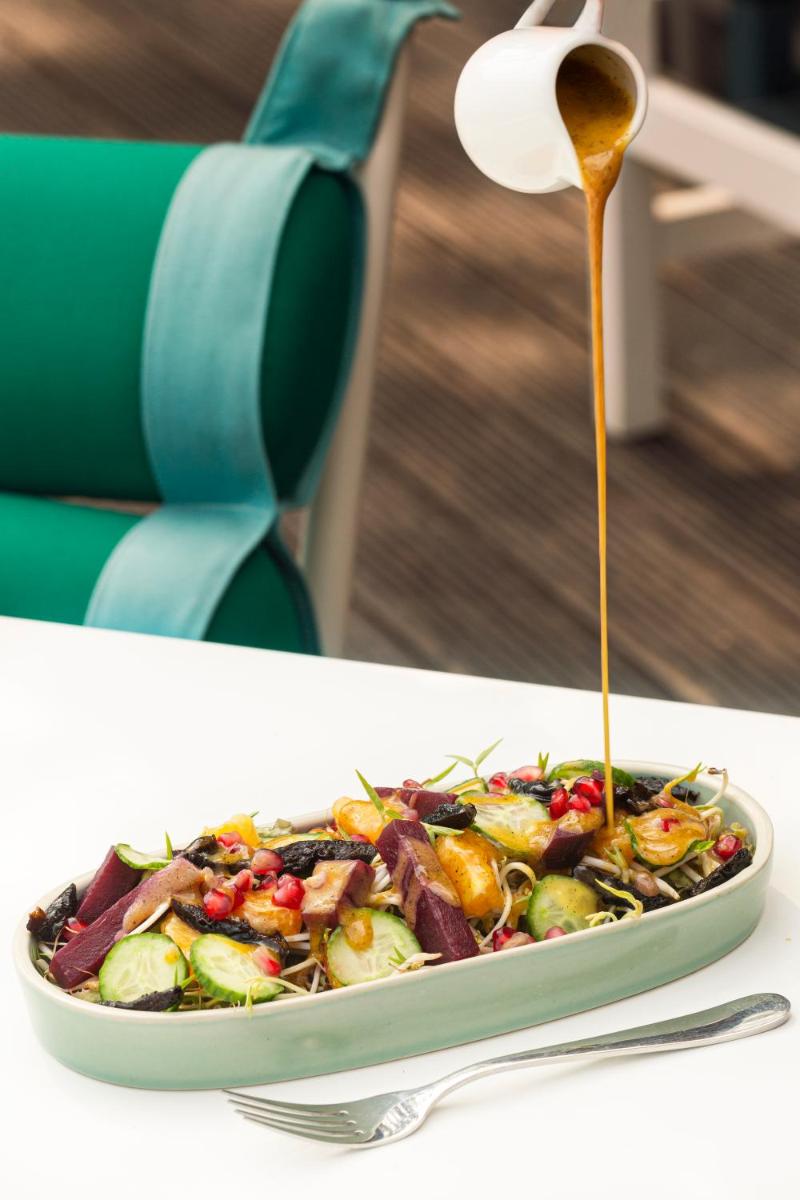 a plate of salad with a drizzle of sauce at Hyatt Hyderabad Gachibowli in Hyderabad