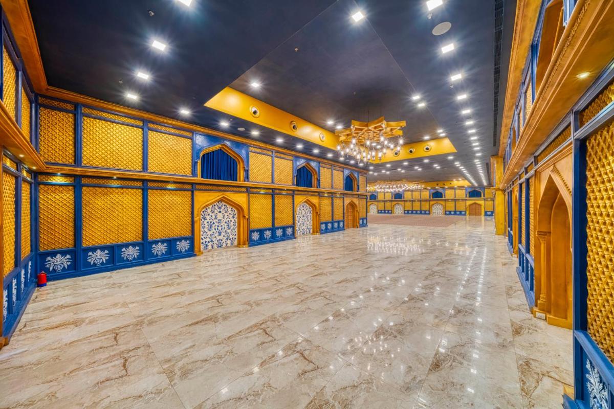 a large ballroom with blue and yellow walls and a large dance floor at Holiday Inn Kolkata Airport by IHG in Kolkata