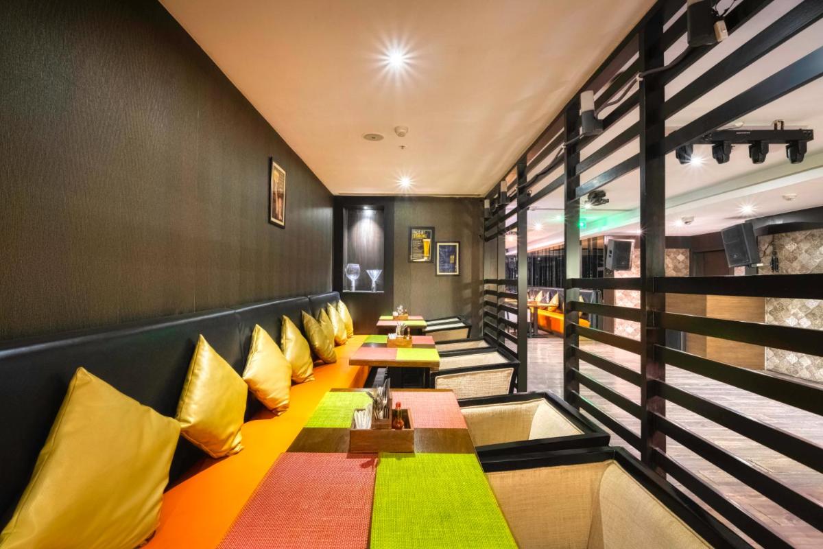 a restaurant with yellow and green pillows and tables at Holiday Inn Kolkata Airport by IHG in Kolkata