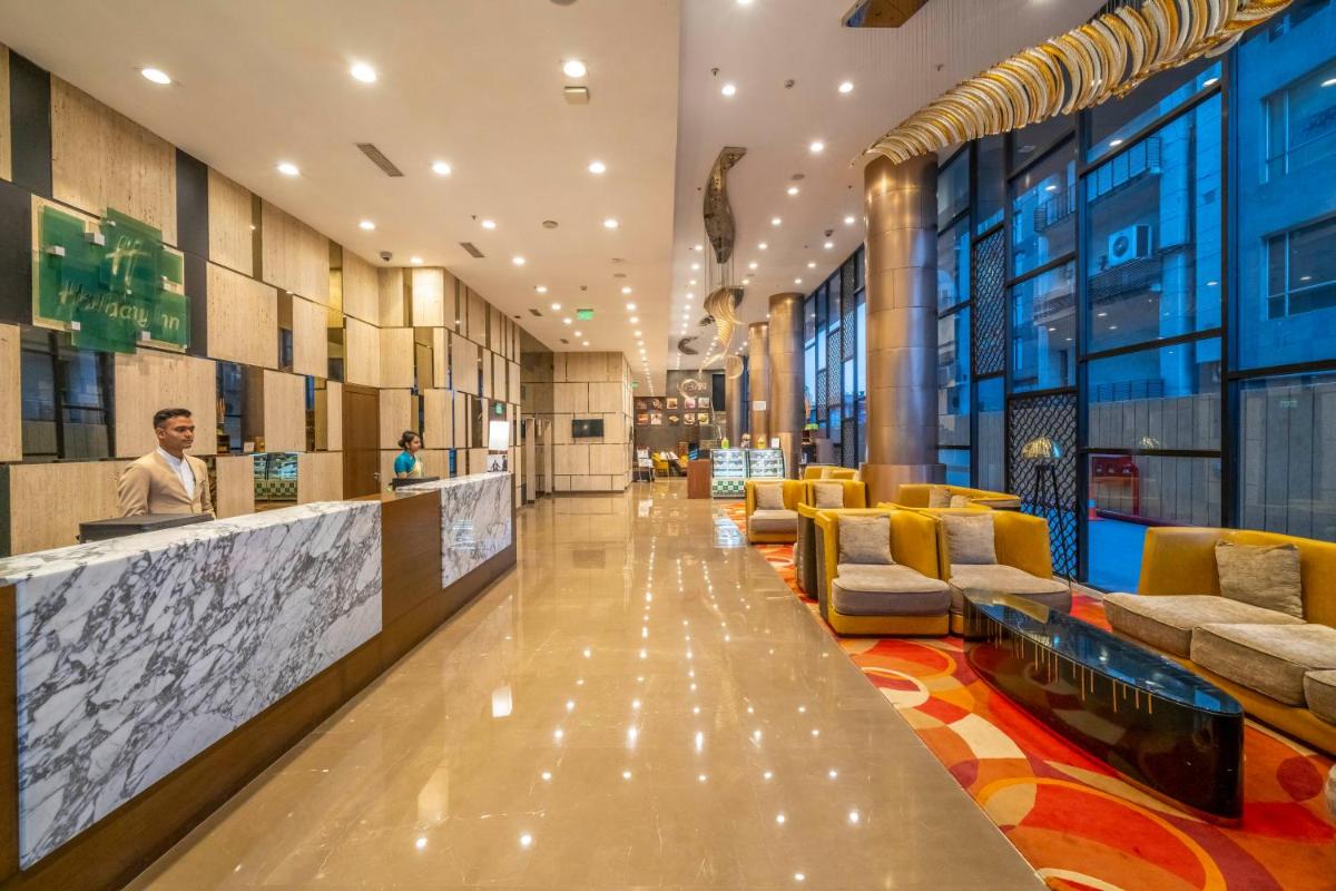 a lobby with couches and a bar in a building at Holiday Inn Kolkata Airport by IHG in Kolkata